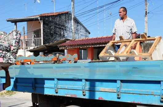 Homem leva sofá para jogar no caminhão Homem leva sofá para jogar no caminhão