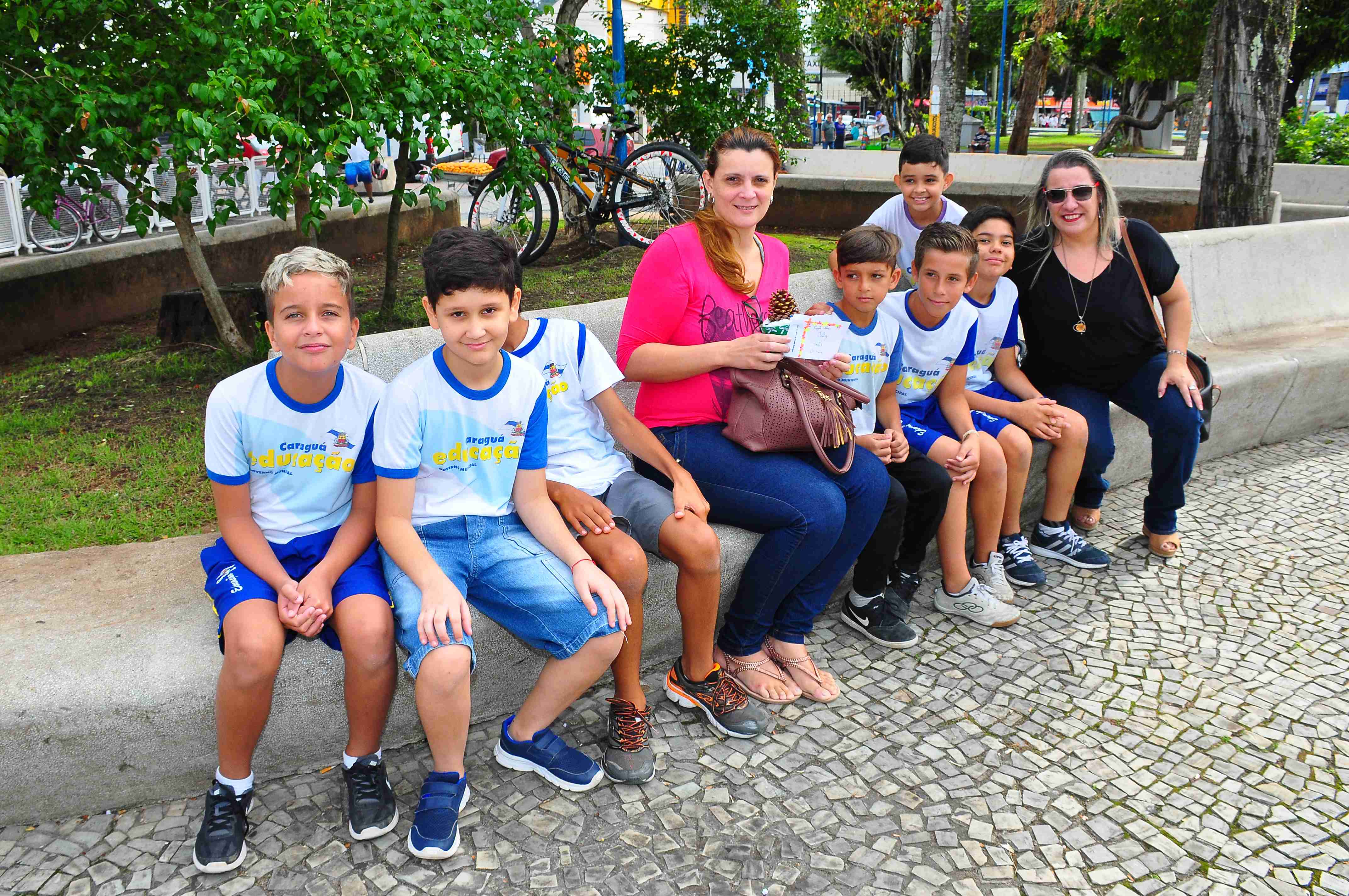 Alunos do Projeto Valores, de escola no Indaiá, encerram atividades com distribuição de pequenas árvores de Natal na Praça do Coreto 