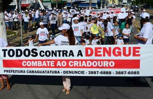 11_27_Pessoas vestem camisa branca e faixa com frase todos contra a dengue