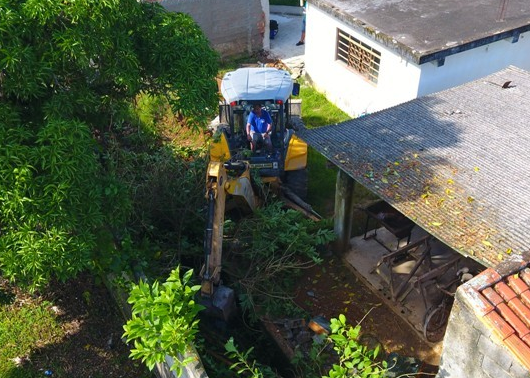 Foto aérea de escavadeira fazendo limpeza de córrego