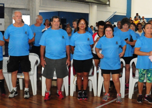 Idosos posando para a foto vestidos com a camiseta do evento